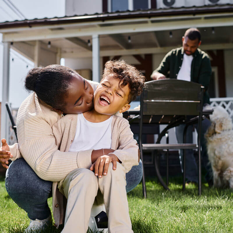 A happy family in front of their Cumming, GA home, representing homeowners' insurance.